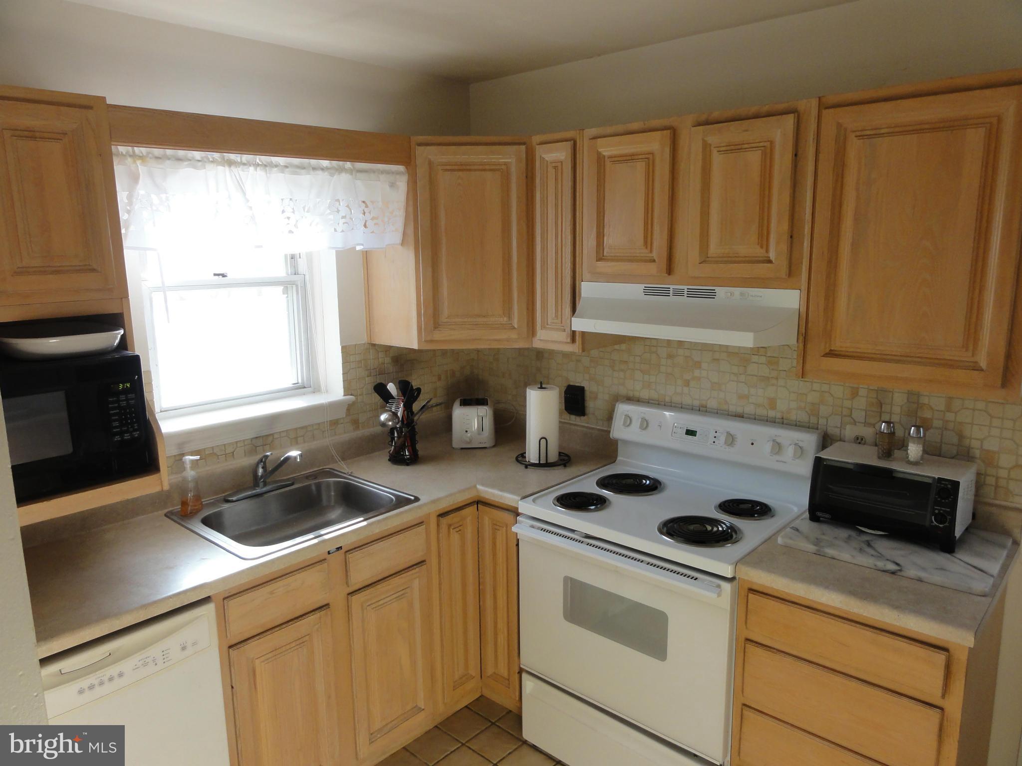 5912 Backlick Road Springfield, VA 22150 - Photo 13 of 28 a kitchen with a stove a sink a refrigerator and cabinets
