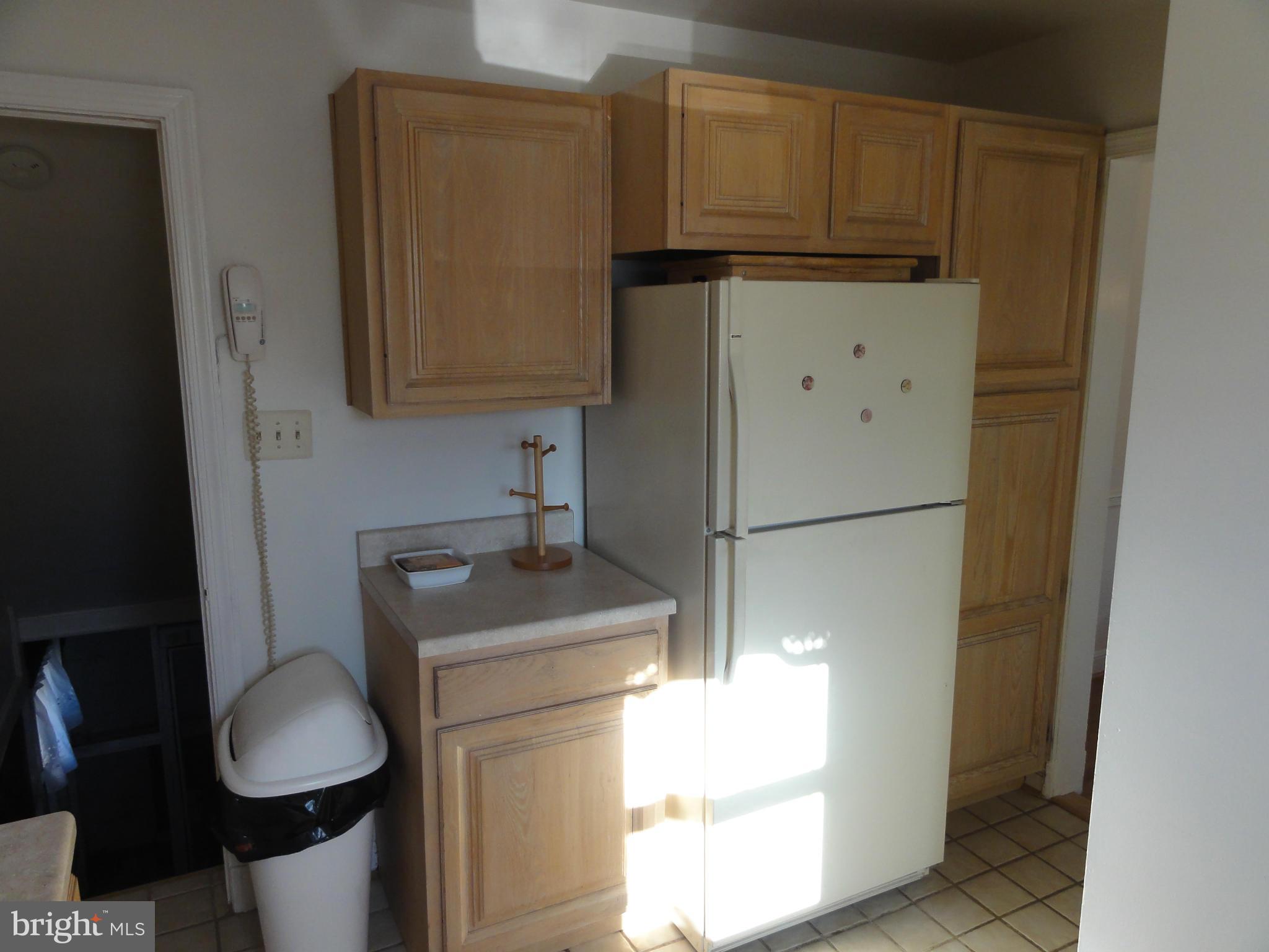 5912 Backlick Road Springfield, VA 22150 - Photo 14 of 28 a kitchen with cabinets and a refrigerator