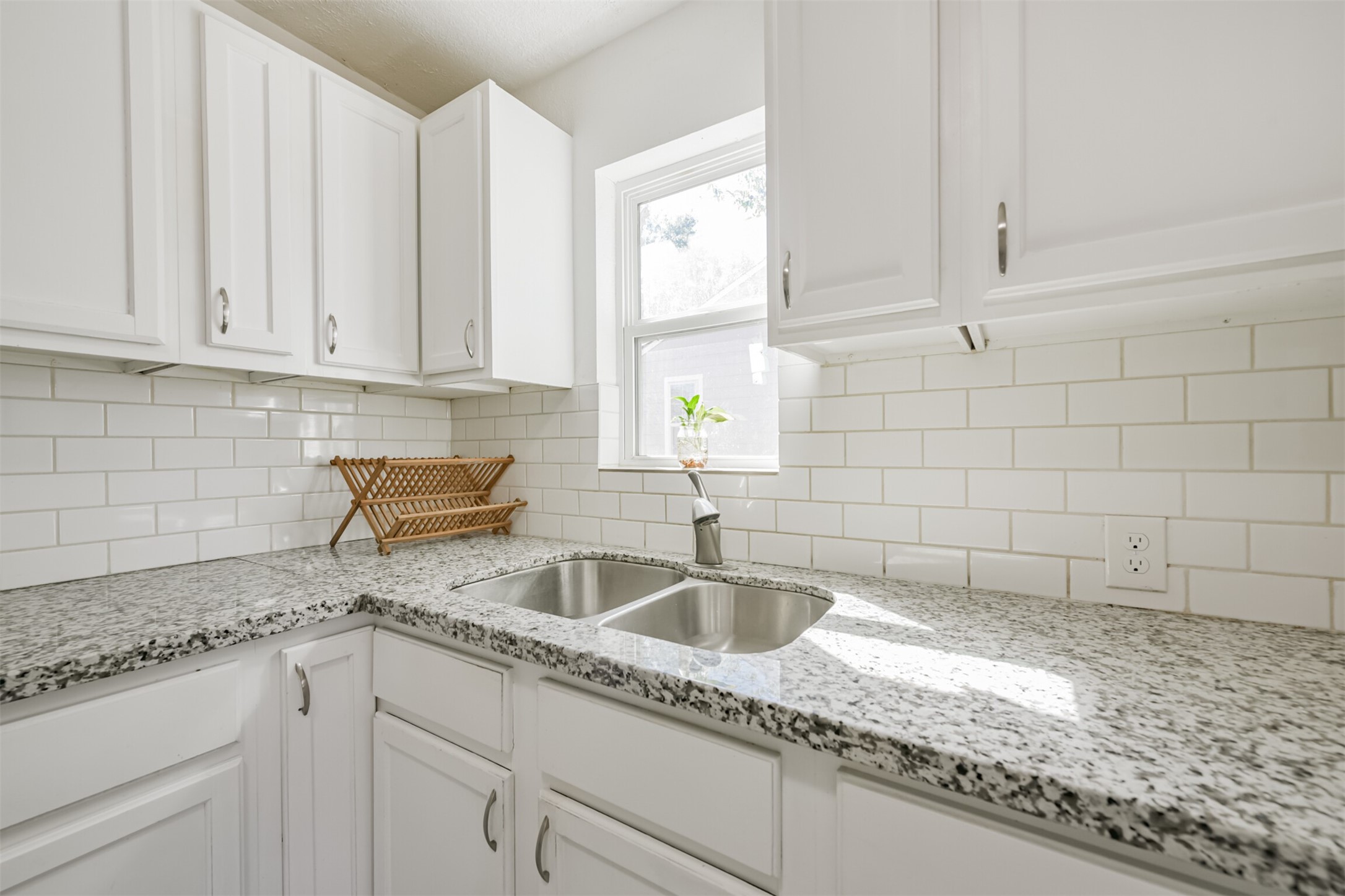 7546 Greendowns Street Houston, TX 77087 - Photo 14 of 33 a kitchen with granite countertop white cabinets and window