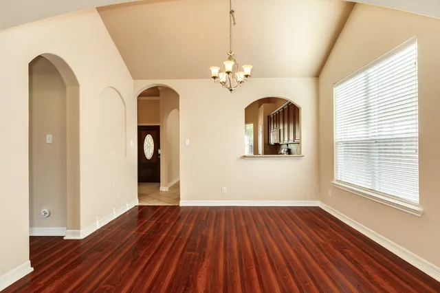 a view of a room with wooden floors and ceiling fan