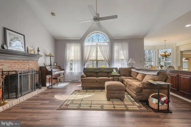 a living room with furniture a fireplace and a large window