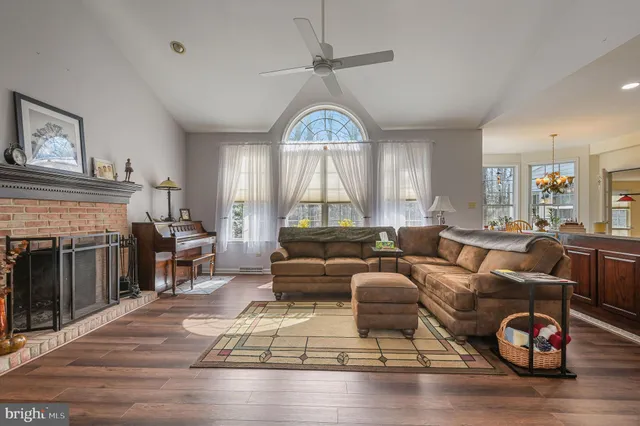 a living room with furniture a fireplace and wooden floor