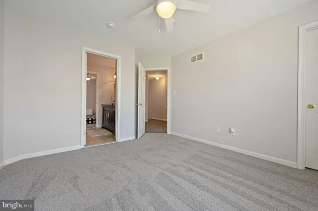 a view of a room with wooden floor and mirror