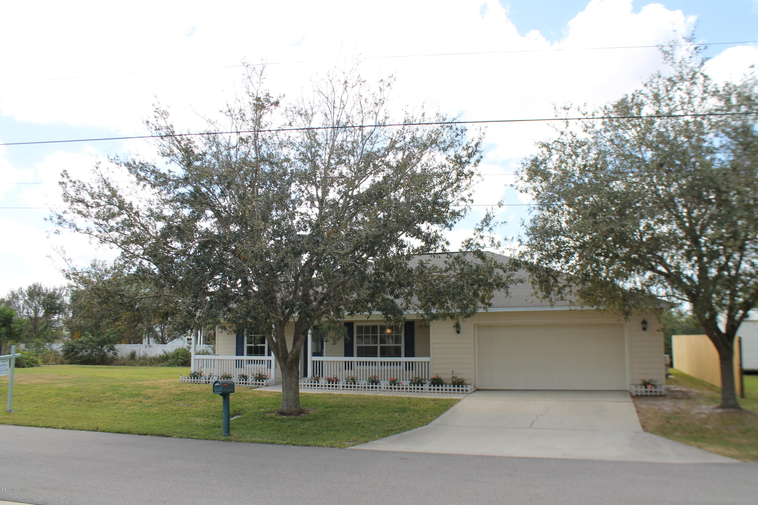 575 Amber Lane Cocoa, FL 32926 - Photo 2 of 16 a view of a white house with a big yard and large trees