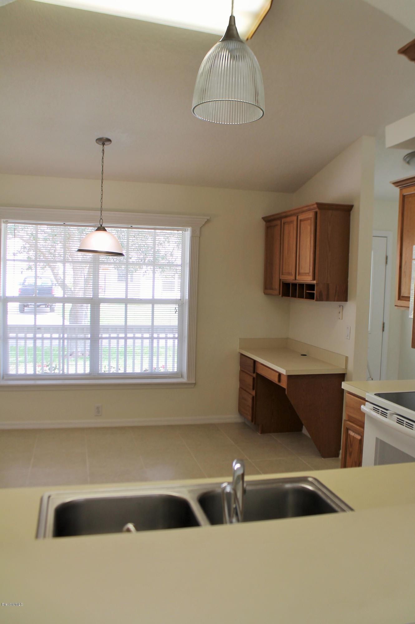 575 Amber Lane Cocoa, FL 32926 - Photo 7 of 16 a kitchen with a window and chandelier