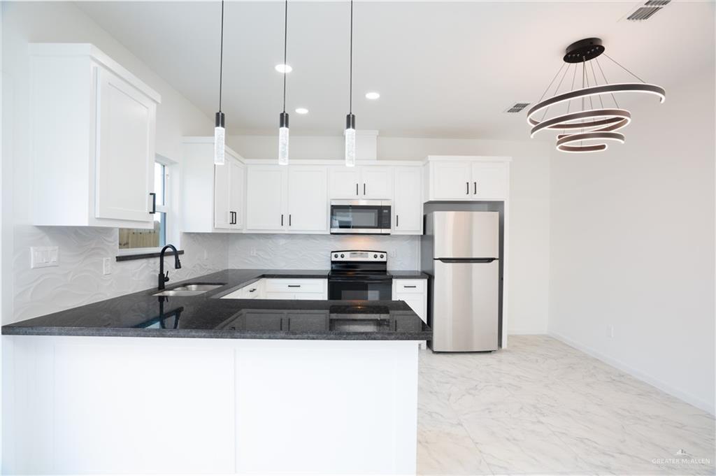 1408 South Xanthia Street, Unit 2 Alton, TX 78573 - Photo 11 of 18 a kitchen with kitchen island a counter top space appliances and cabinets