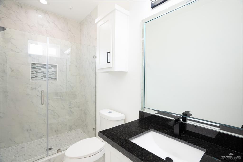 1408 South Xanthia Street, Unit 2 Alton, TX 78573 - Photo 12 of 18 a bathroom with a sink a toilet and shower