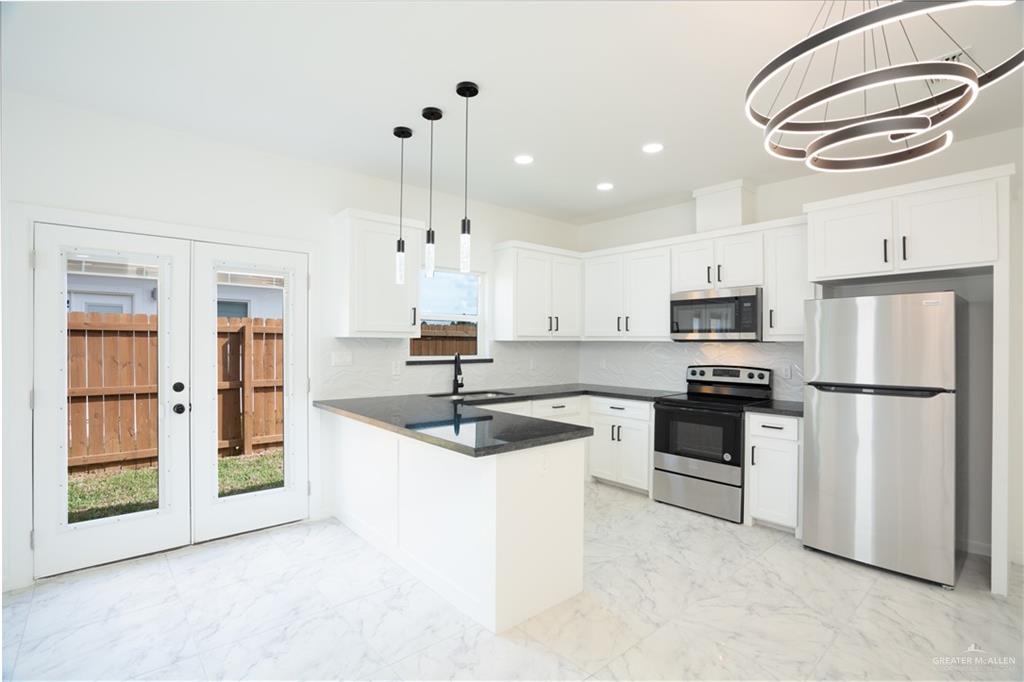 1408 South Xanthia Street, Unit 2 Alton, TX 78573 - Photo 4 of 18 a kitchen with granite countertop a sink stainless steel appliances and cabinets