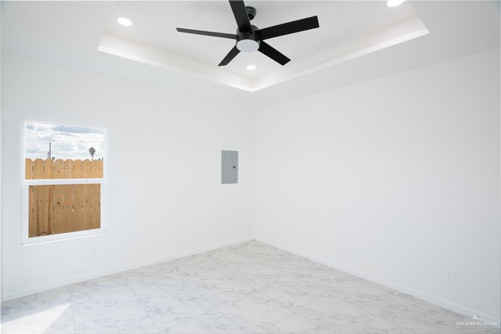 1408 South Xanthia Street, Unit 2 Alton, TX 78573 - Photo 9 of 18 an empty room with a window and a ceiling fan