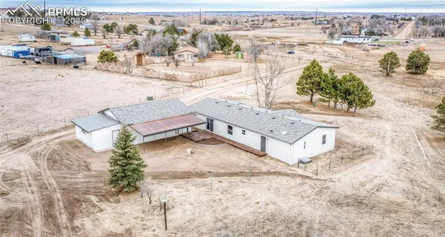 an aerial view of a house with a yard and lake view