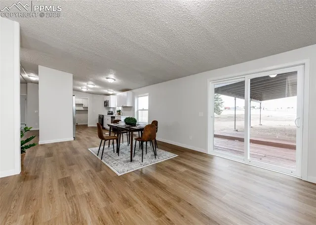 a kitchen with stainless steel appliances granite countertop a refrigerator a sink dishwasher a stove and white countertops with wooden floor