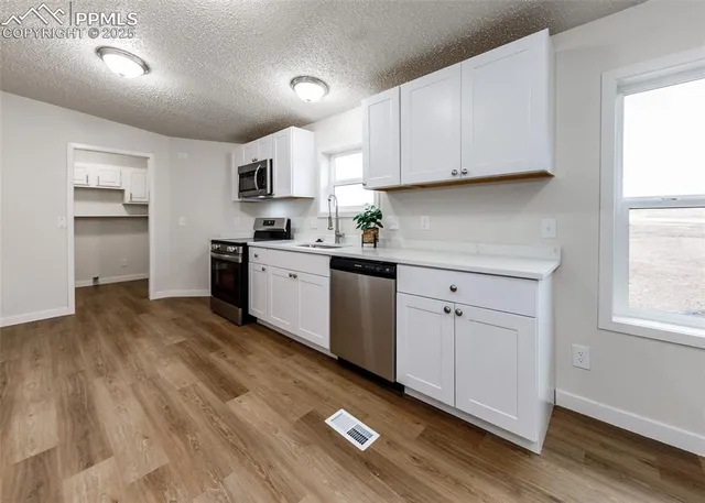 a kitchen with stainless steel appliances a stove a sink a microwave and cabinets