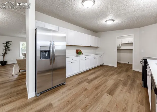a kitchen with stainless steel appliances white cabinets and a refrigerator