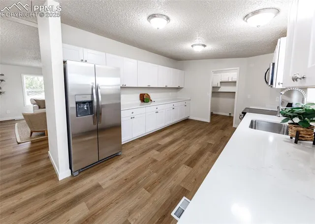 a view of a kitchen with wooden floor and a sink