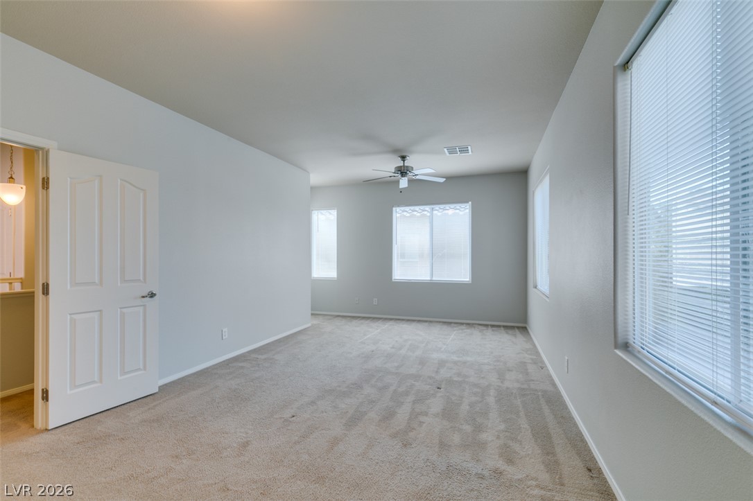 8937 Caledon Ridge Court Las Vegas, NV 89149 - Photo 33 of 43 A spacious and luminous bedroom with soft carpeting and ample natural light through multiple windows.