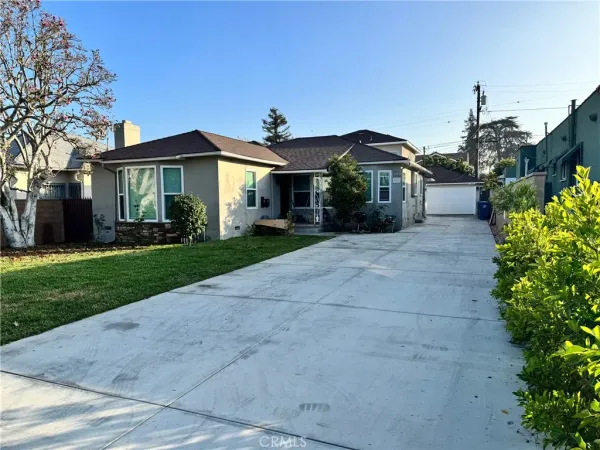 a front view of a house with a yard and potted plants