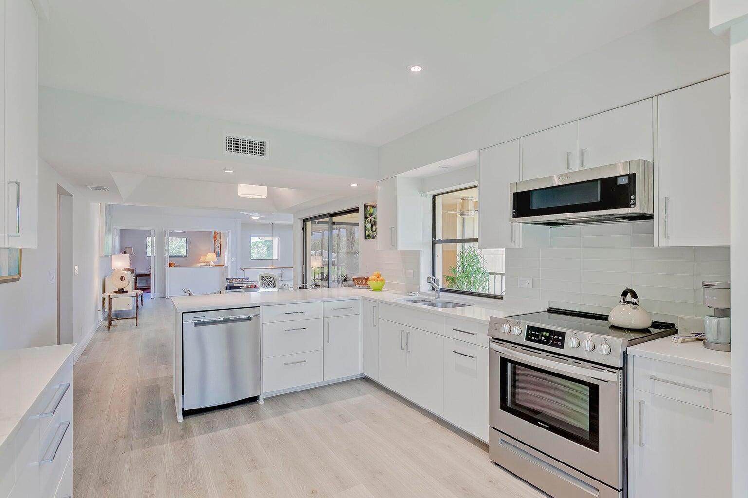 a kitchen with appliances a sink and cabinets
