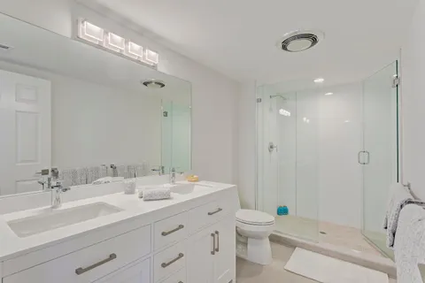 a bathroom with a double vanity sink toilet and shower