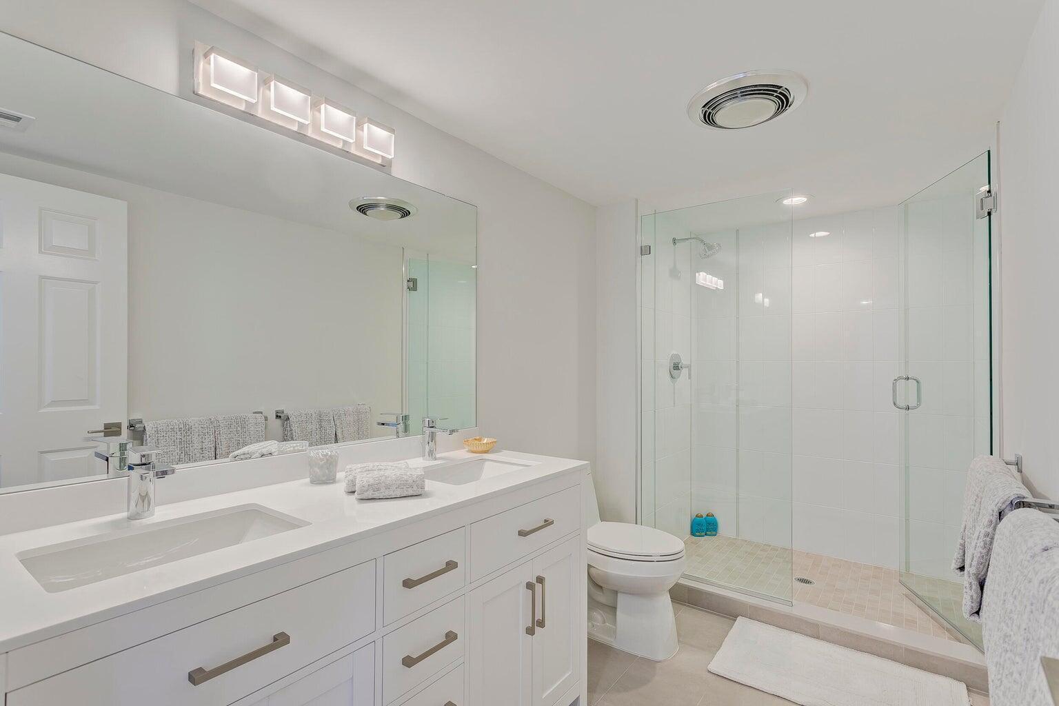 17053 Waterbend Drive, Unit 231 Jupiter, FL 33477 - Photo 17 of 26 a bathroom with a double vanity sink toilet and shower