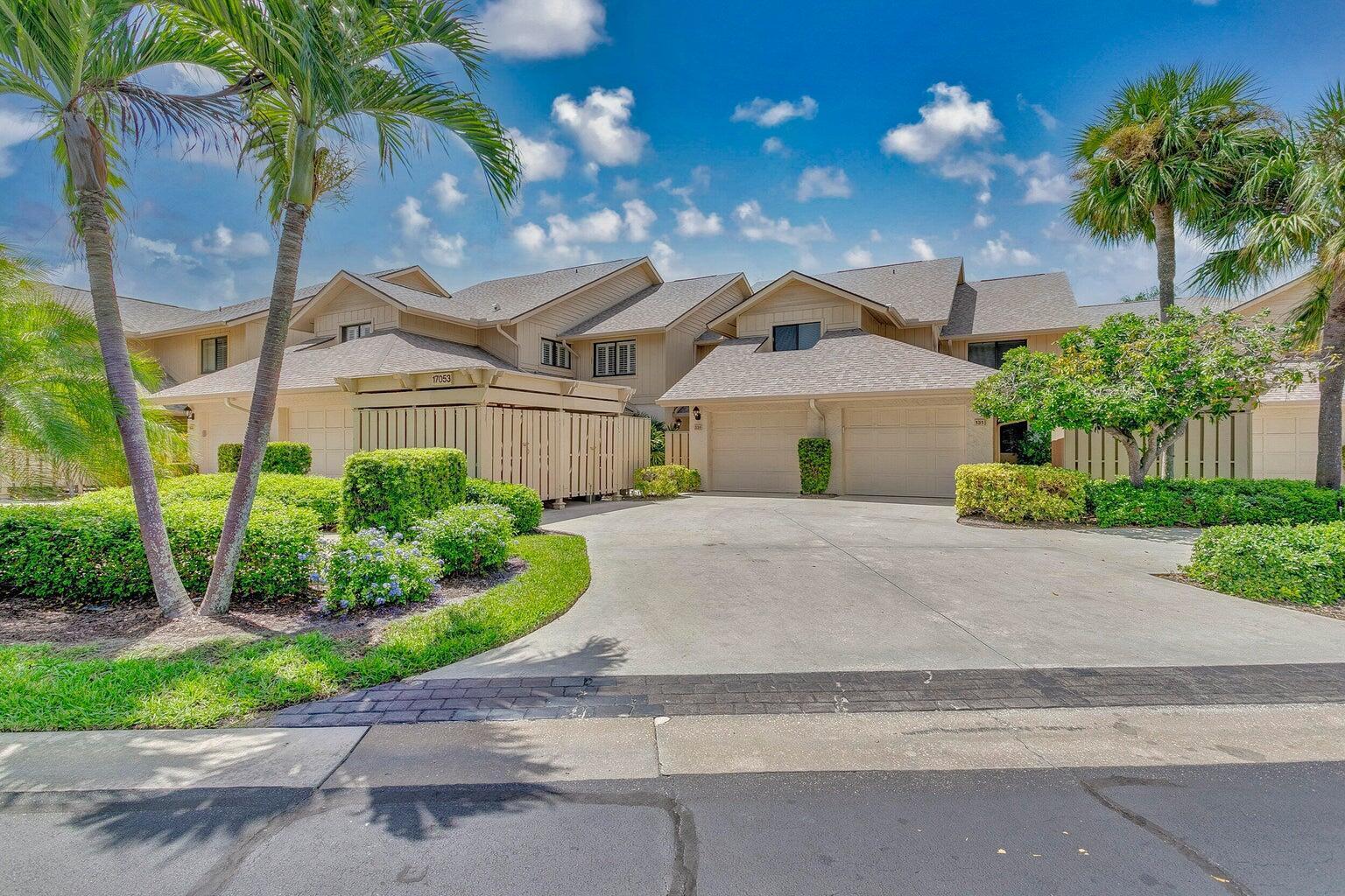 17053 Waterbend Drive, Unit 231 Jupiter, FL 33477 - Photo 2 of 26 a front view of a house with a garden and plants