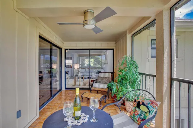a living room with furniture floor to ceiling window and wooden floor