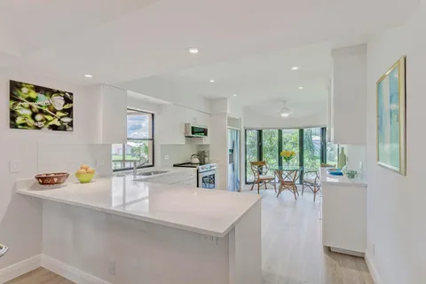 a kitchen with a table chairs and a view of living room