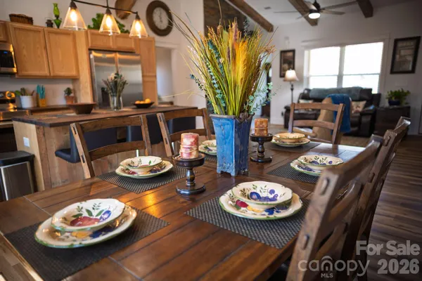 a kitchen with stainless steel appliances granite countertop a refrigerator a sink dishwasher a stove and white countertops with wooden floor