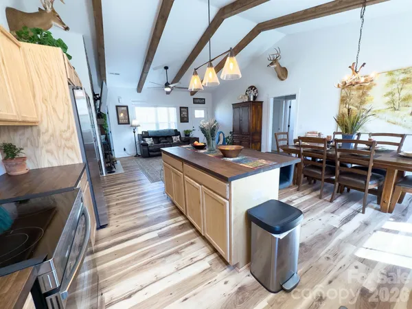 a dining room with stainless steel appliances furniture a window and a kitchen view