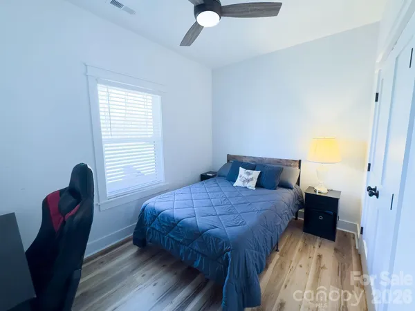 a bedroom with a bed and a flat tv screen on the dresser