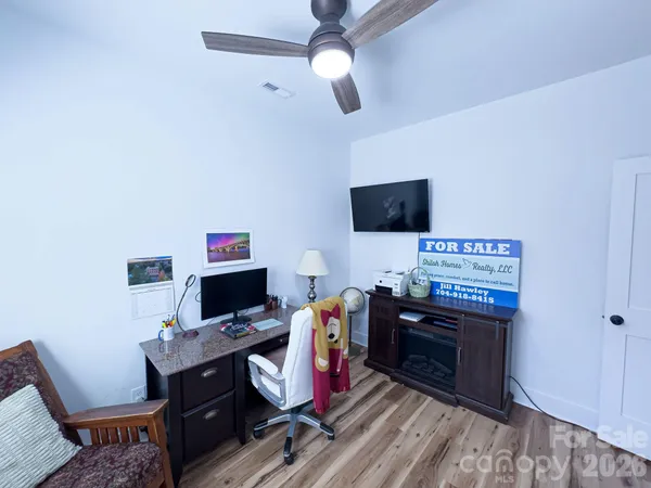 a view of a workspace with furniture and a window