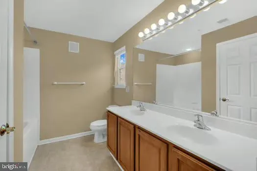 a spacious bathroom with a double vanity sink toilet and a mirror