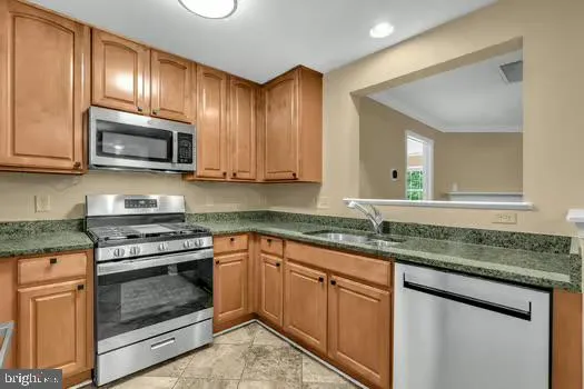 a kitchen with granite countertop cabinets stainless steel appliances and a sink