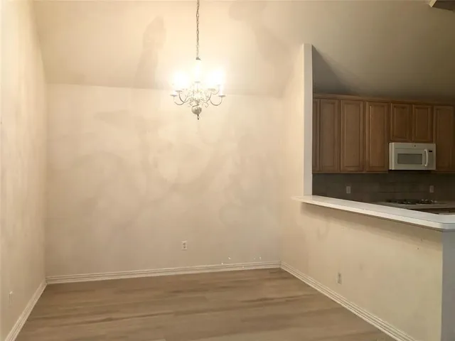 a view of a room with wooden floor and cabinets