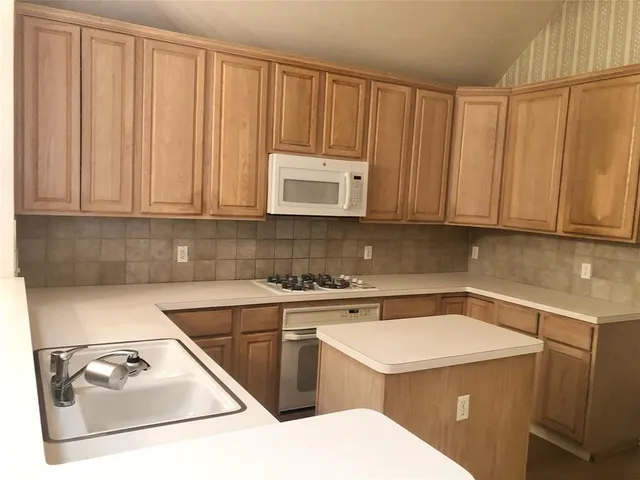 a kitchen with a sink cabinets and appliances