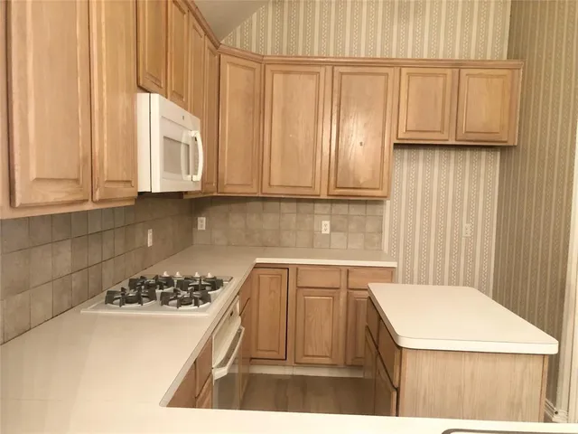 a kitchen with a stove a refrigerator and cabinets