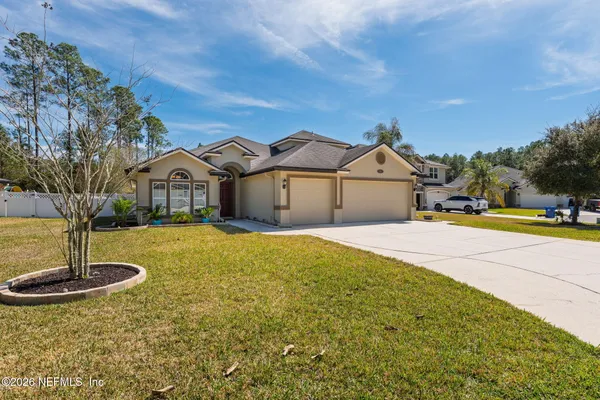 a large kitchen with a large counter top a sink stainless steel appliances and cabinets