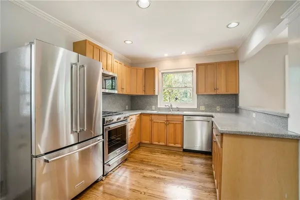 a kitchen with stainless steel appliances granite countertop a refrigerator a sink and a stove