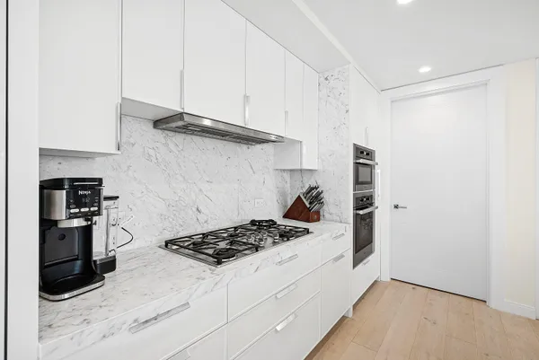 a kitchen with stainless steel appliances granite countertop a refrigerator and a stove top oven