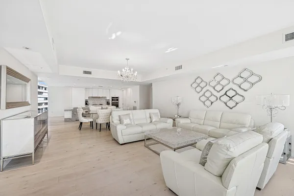 a living room with furniture a flat screen tv and kitchen view