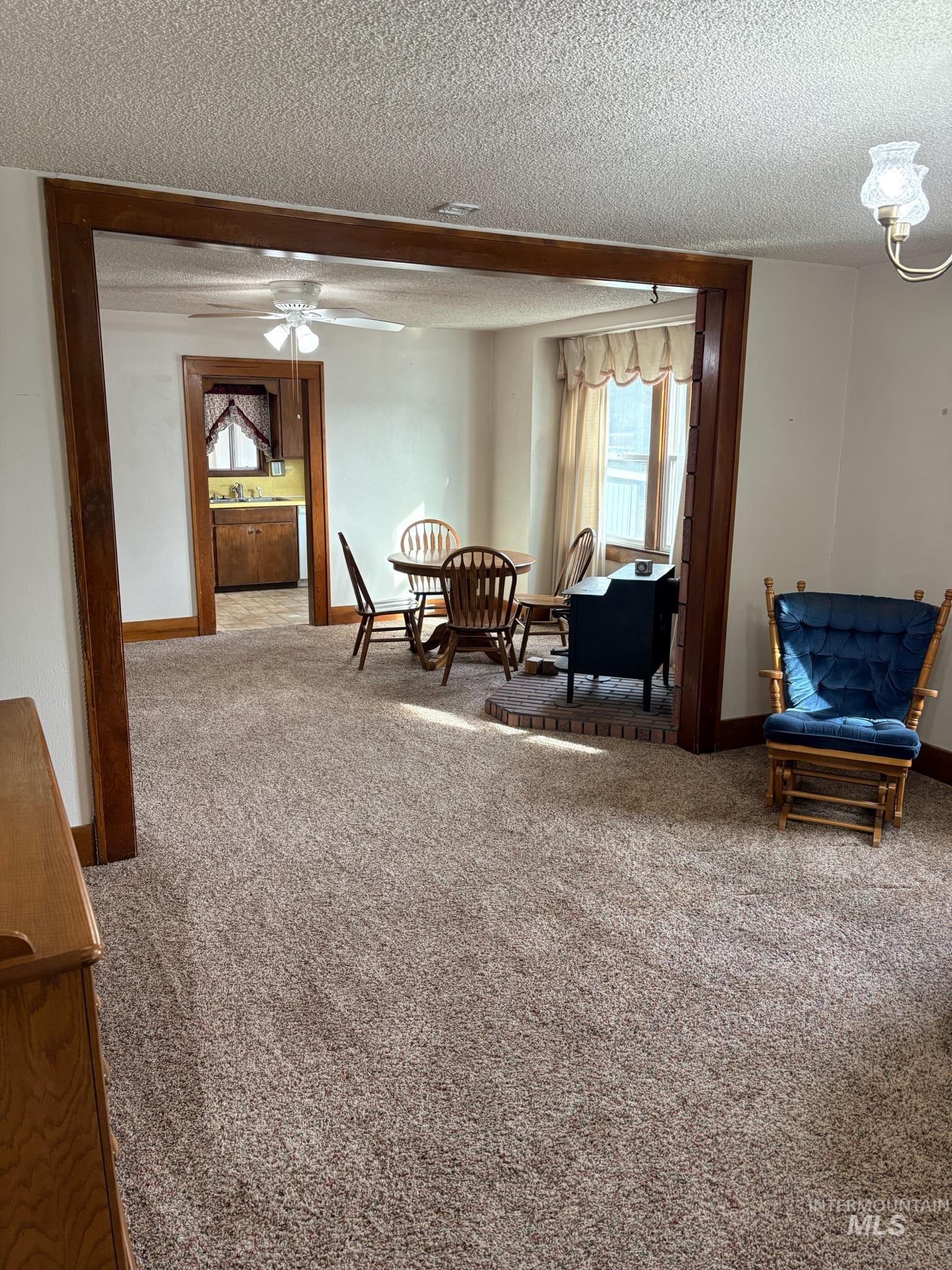627 Southwest 3rd Street Fruitland, ID 83619 - Photo 6 of 35 Living area featuring carpet floors, a textured ceiling, and a ceiling fan