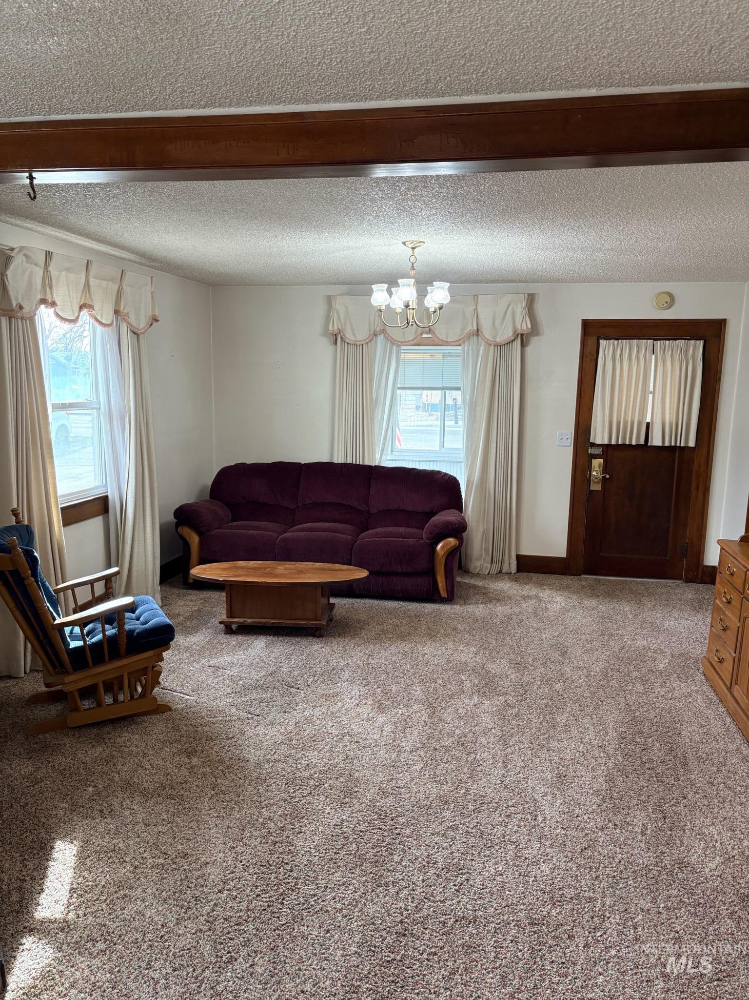 627 Southwest 3rd Street Fruitland, ID 83619 - Photo 9 of 35 Carpeted living area with a chandelier and a textured ceiling