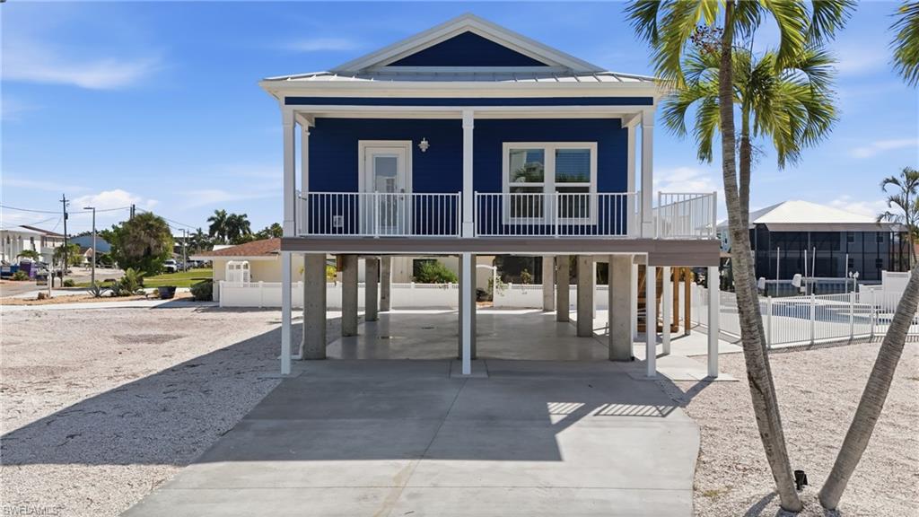 1 Fairview Boulevard Fort Myers Beach, FL 33931 - Photo 29 of 48 Elevated coastal-style residence featuring a vibrant blue exterior and white trim - Virtually Edited Image