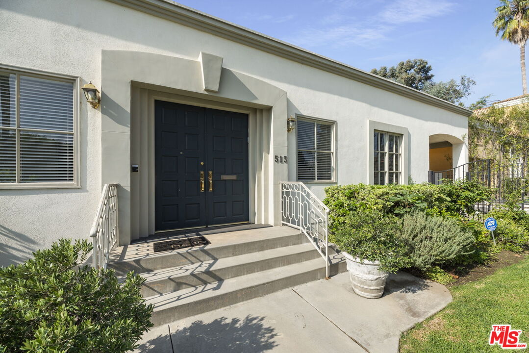 513 Foothill Road Beverly Hills, CA 90210 - Photo 3 of 9 a front view of a house with potted plants