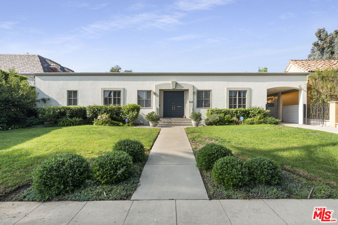 513 Foothill Road Beverly Hills, CA 90210 - Photo 4 of 9 a front view of a house with yard and green space