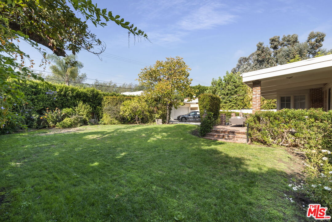 513 Foothill Road Beverly Hills, CA 90210 - Photo 5 of 9 a garden with trees in front of it