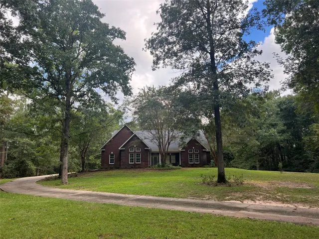 a front view of a house with a yard and trees