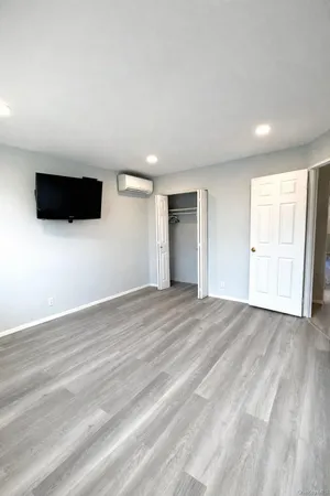 a view of empty room with wooden floor and windows