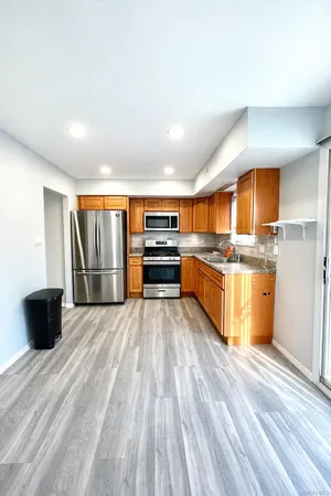 a kitchen with stainless steel appliances kitchen island granite countertop a stove and a refrigerator