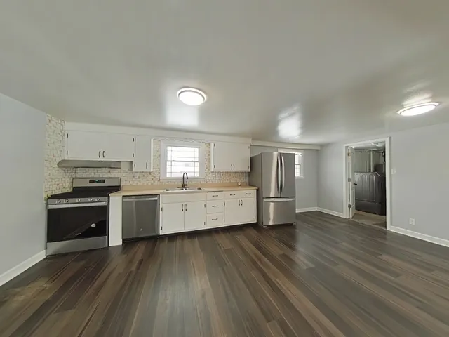 a kitchen with stainless steel appliances a refrigerator and a stove top oven