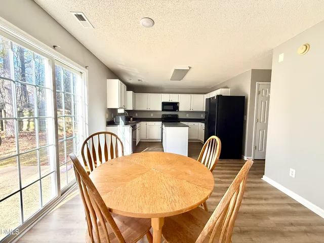 a dining room with furniture and a floor to ceiling window